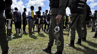 A member of the Bolivarian National Guard holds handcuffs after taking them off from inmates of a rugby team during the Penitentiary Rugby Tournament organized by the Santa Teresa Foundation, at the sports field Hacienda Santa Teresa in La Victoria, Aragua State, Venezuela, on December 1, 2018. (AFP)