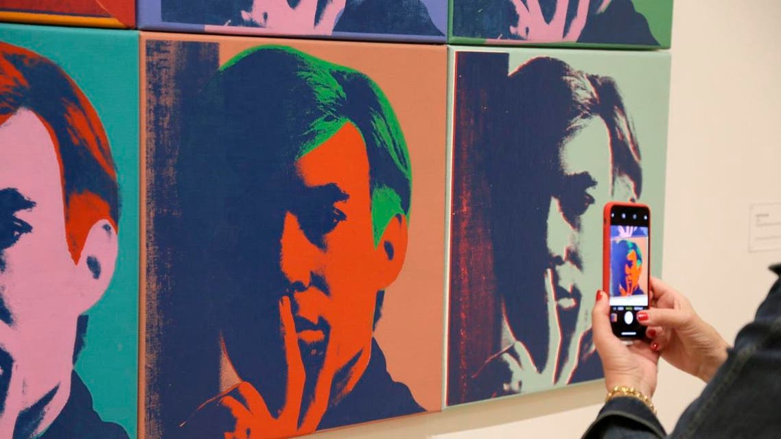 A woman records one of a series of self portraits at the exhibition, “Andy Warhol - From A to B and Back Again,” in San Francisco. (AP)