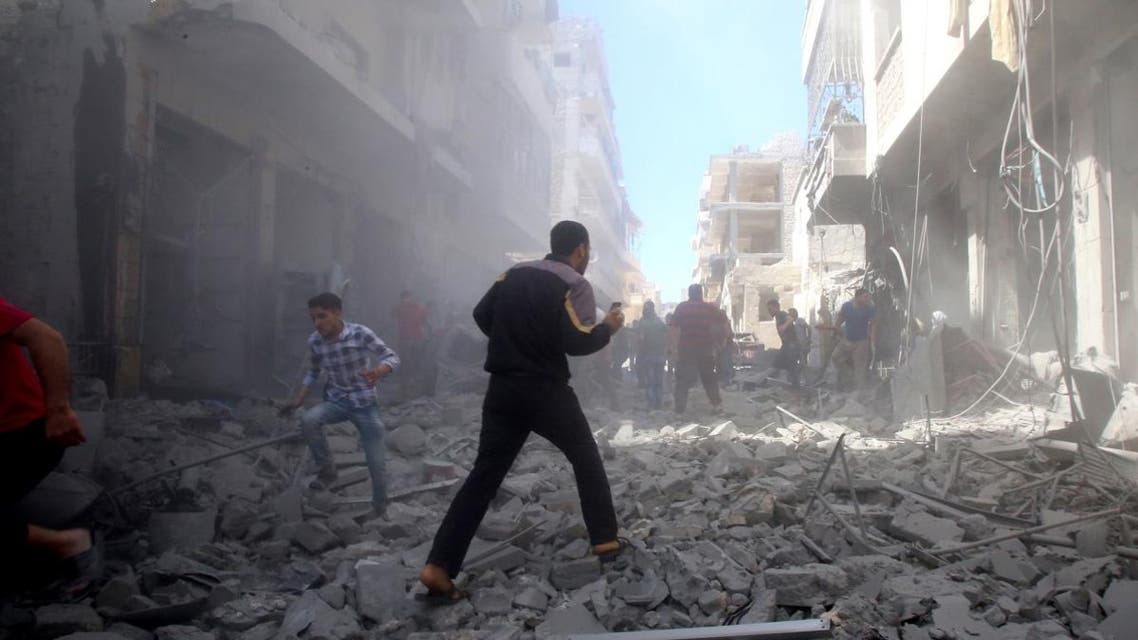 People walk among debris following a reported air strike by regime forces and their allies in the extremist-held Syrian town of Maaret Al-Noman in the southern Idlib province, on May 26, 2019. (AFP)