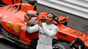 Lewis Hamilton holds his red helmet to tribute Niki Lauda after he won the Monaco Formula One Grand Prix race on May 26, 2019. (AP)