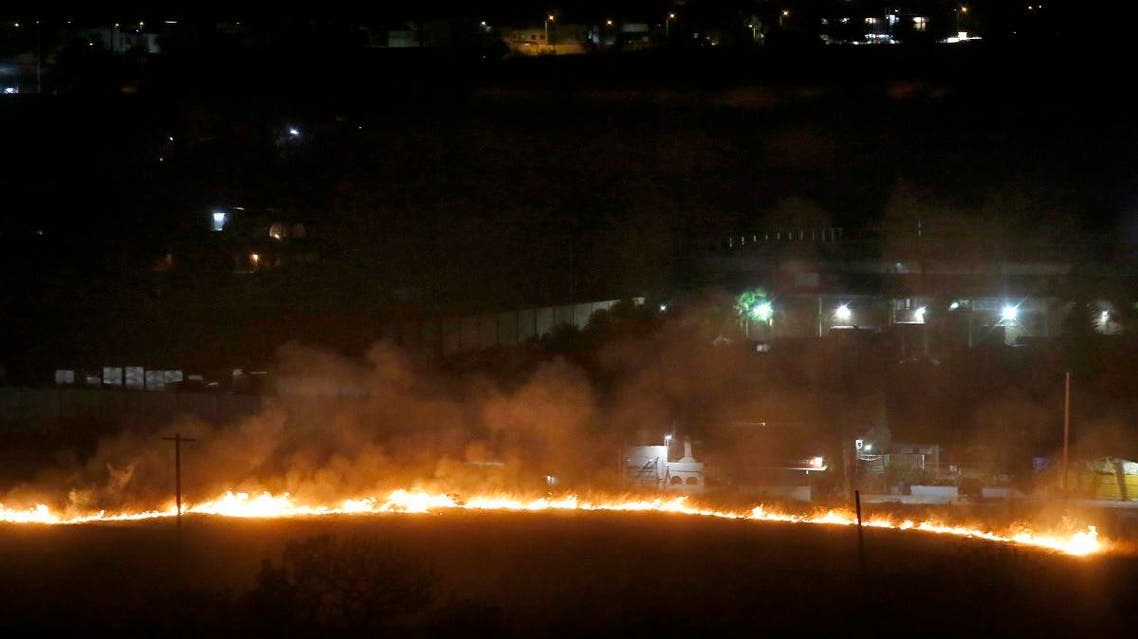 A line of fire running down a hill in La Primavera forest reaches the residential area of Pinar de la Venta in Zapopan, Jalisco State, Mexico, early on May 15, 2019. (AFP)