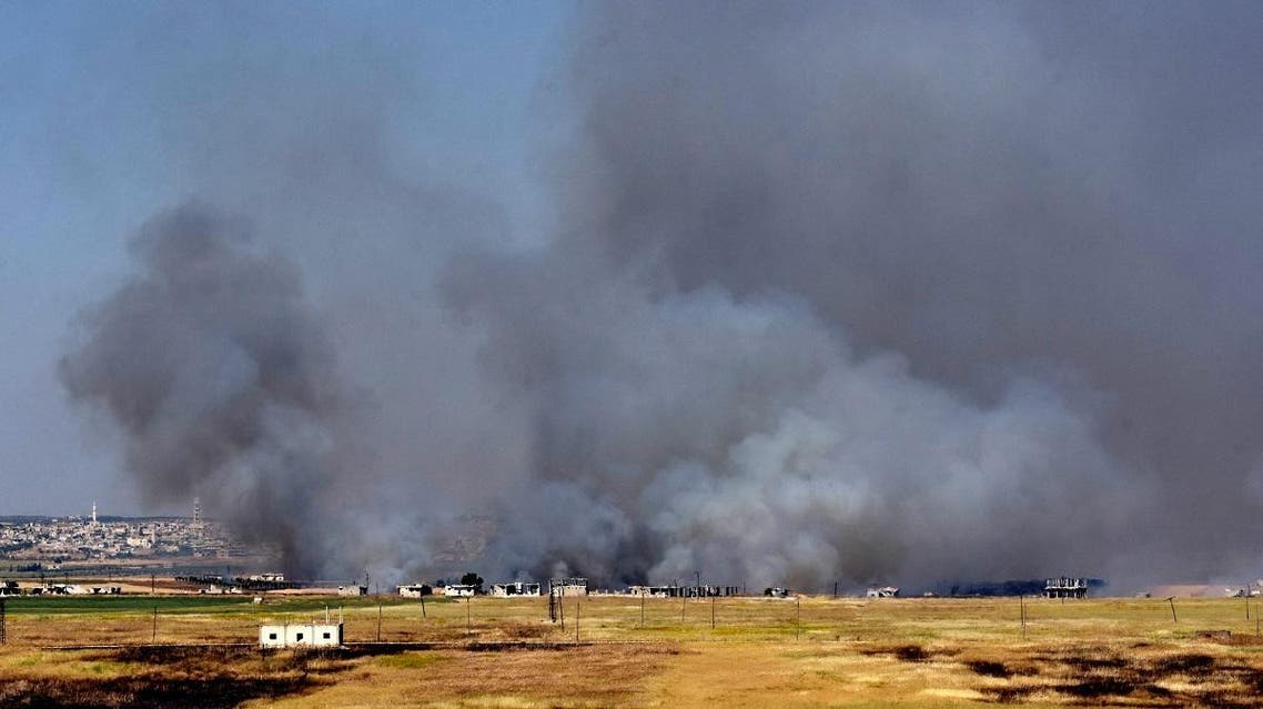 Smoke billows above buildings in the town of Kafr Nabuda in the north of the Syrian Hama province during reported air strikes by Syrian regime forces on May 26, 2018. (File photo: AFP)