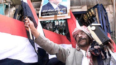 A Yemeni man listens to the radio as he sells the national flag in Sanaa on 19 September 1999. (File photo: AFP)