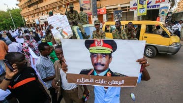 Sudanese supporters of the ruling Transitional Military Council (TMC) hold up a sign showing a portrait of its head General Abdel Fattah al-Burhan with a caption below reading in Arabic “Al-Burhan, upon you is the trust,” during a rally in the center of the capital Khartoum on May 31, 2019. (AFP)