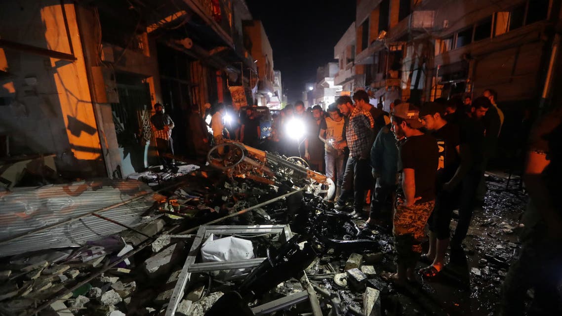 People look at debris at the site of a car bomb blast in Azaz, Syria June 2, 2019. REUTERS/Khalil Ashawi