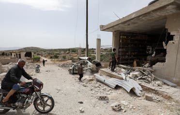 A man drives his motorcycle near a building that was damaged during an air strike by the Syrian government forces in town of Kafr Aweid, in the extremist-controlled region of Idlib on May 23, 2019. (File photo: AFP)