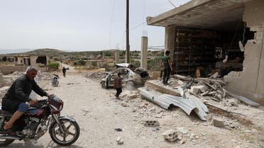 A man drives his motorcycle near a building that was damaged during an air strike by the Syrian government forces in town of Kafr Aweid, in the extremist-controlled region of Idlib on May 23, 2019. (AFP)
