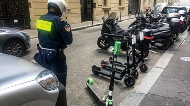 An official from the Mayor of Paris’ office moves electric scooters from car parking spaces into those for motorcycles on a road in Paris on June 6, 2019. (AFP)