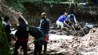 Bosnian workers along side members of the International Committee for Missing Persons (ICMP) work on a newly discovered mass grave on Mt. Igman, near Sarajevo, on June 6, 2019. (AFP)