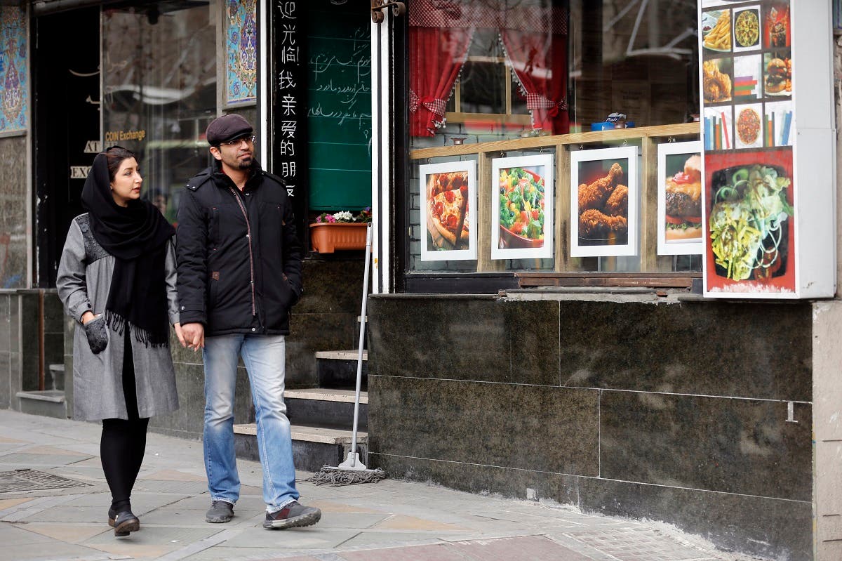 File photo of an Iranian couple walk past a restaurant in the capital Tehran. (AFP)