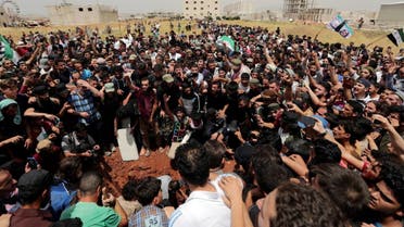 People gesture and chant slogans during the funeral of Abdelbasset al-Sarout. (Reuters)