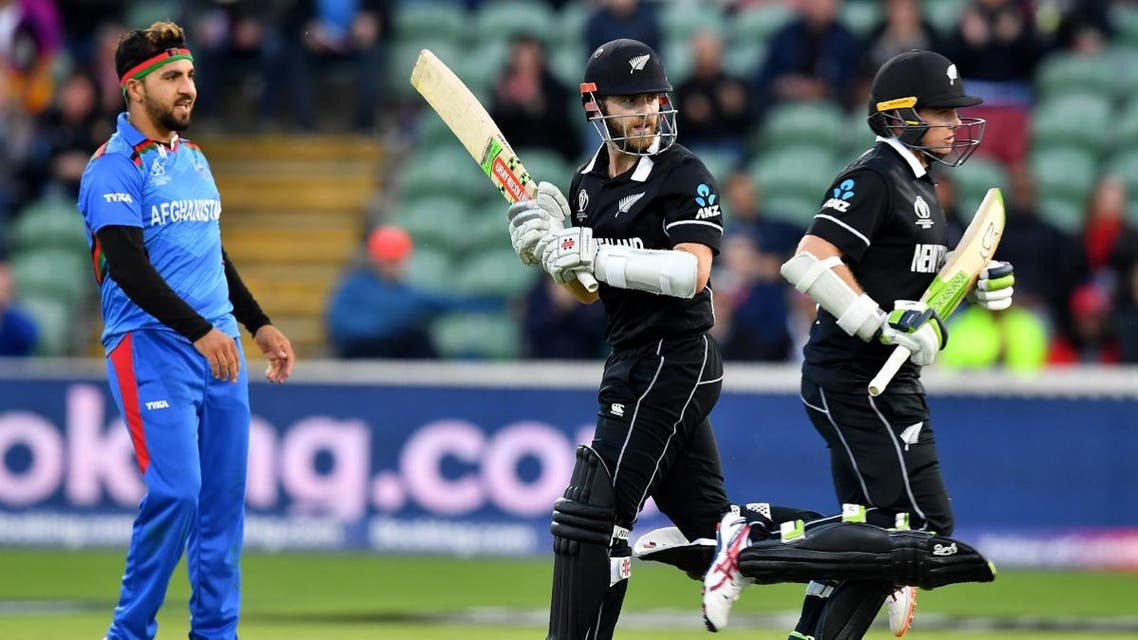 Afghanistan’s Aftab Alam looks on as New Zealand’s captain Kane Williamson (C) and Tom Latham (R) run between wickets to end the match during the 2019 Cricket World Cup group stage match in Taunton, southwest England, on June 8, 2019. (AFP)