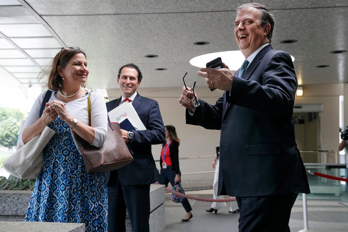 Marcelo Ebrard, Mexico’s Secretary of Foreign Affairs, (right), laughs as a reporter asks a question after he spoke to the media while leaving a meeting to talk about tariffs at the State Department, on June 6, 2019, in Washington. (AP)