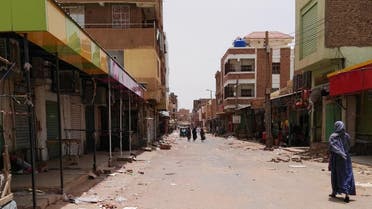 A Sudanese woman walks past closed shops in a commercial street in Khartoum's twin city Omdurman on the first day of a civil disobedience campaign across Sudan on June 9, 2019. (AFP)