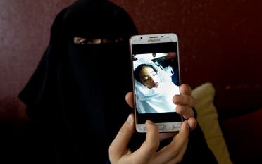 Muna Awad, mother of 5-year-old Aisha al-Loulu, shows a photo of her daughter while in a Jerusalem hospital, at the family home in Bureij refugee camp in central Gaza Strip. (AP)