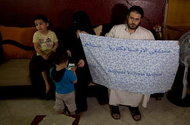 Waseem, father of 5-year-old Aisha a-Lulu, holds the hospital bed sheet his deceased daughter was covered with when she was sent home from a Jerusalem hospital, at the family home in Burij refugee camp, central Gaza Strip. (AFP)