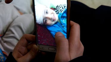In this May 27, 2019 photo, parents of 5-year-old Aisha a-Lulu, show a mobile photo of their daughter Aisha when she was in a Jerusalem hospital. (AP)