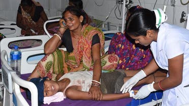 An Indian child receives medical treatment due to Acute Encephalitis Syndrome (AES) as family members react in a hospital in Muzaffarpur on June 10, 2019. (AFP)