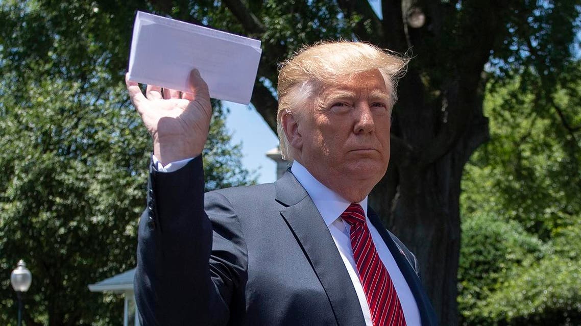 US President Donald Trump holds piece of paper saying it’s his deal with Mexico as he speaks with reporters at the White House, in Washington, DC, on June 11, 2019. (AFP)