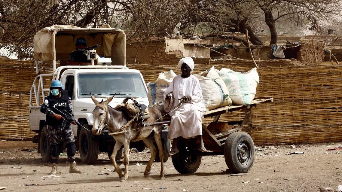 A Sudanese man rides a donkey cart past members of the United Nations African Union Mission in Darfur (UNAMID). (File photo: AFP)