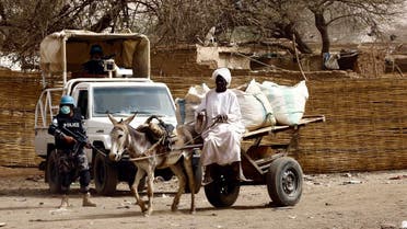 A Sudanese man rides a donkey cart past members of the United Nations African Union Mission in Darfur (UNAMID). (File photo: AFP)