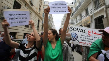 People carry signs as Mourad Eulmi was questioned in court about corruption accusations in Algiers on June 16, 2019. (Reuters)