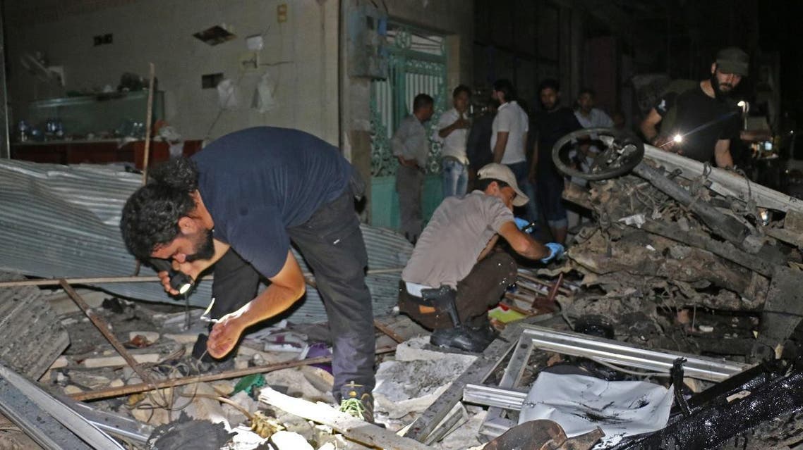 Syrians inspect a car that reportedly exploded in a market in the northern city of Azaz in the jihadist-held Aleppo province near the border with Turkey, late on June 2, 2019. (AFP)