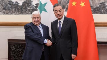 Syrian Foreign Minister Walid Muallem (L) poses for a picture with Chinese Foreign Minister Wang Yi during a meeting at Diaoyutai state guesthouse in Beijing on June 18, 2019. (AFP)