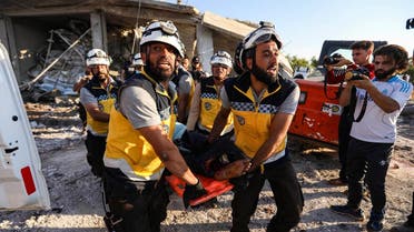 Members of the Syrian Civil Defence carry away a body on a stretcher following a reported government air strike in the village of Benin, about 30 kilometers south of Idlib in northwestern Syria. (AFP)