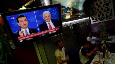 People watch a televised debate between Istanbul's mayoral candidates Imamoglu of CHP and Yildirim of AKP at a cafe in central Istanbul. (Reuters)