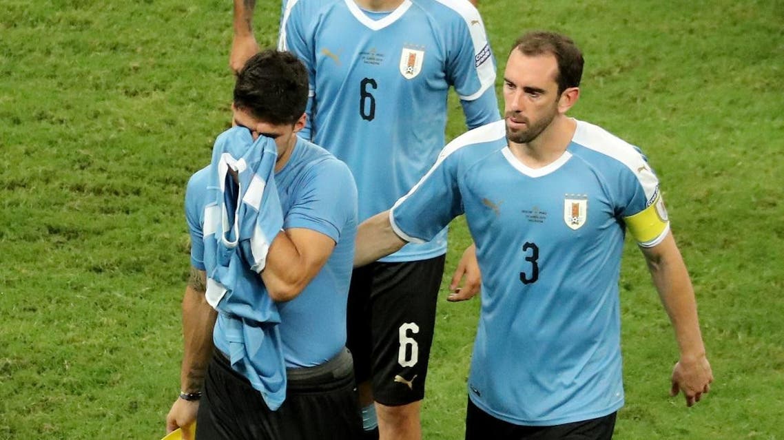 Uruguay's Luis Suarez looks dejected as Diego Godin consoles him. (Reuters)