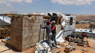 Syrian refugees demolish a concrete wall built inside their tent at a refugee camp in the eastern Lebanese border town of Arsal, Lebanon. (File photo: AP)