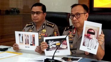 Indonesian police personnel show photographs of leader Para Wijayanto and various seized items, at a press conference in Jakarta on July 1, 2019. (AFP)
