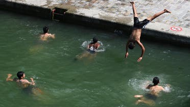 A young man dives into the waters of the Canal Saint-Martin in Paris on June 27, 2019. (AFP)