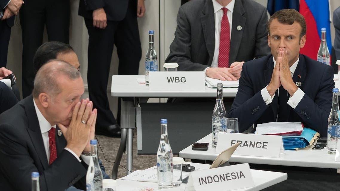 Turkey’s President Recep Tayyip Erdogan (L) and France’s President Emmanuel Macron gesture as they attend a meeting on the digital economy at the G20 Summit in Osaka on June 28, 2019. (AFP)