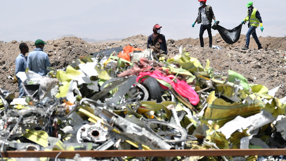 A crew working with an investigative team to clear the site after the Sunday crash of the Ethiopian Airlines operated Boeing 737 MAX aircraft, carry debris at Hama Quntushele village in the Oromia region, on March 13, 2019.
