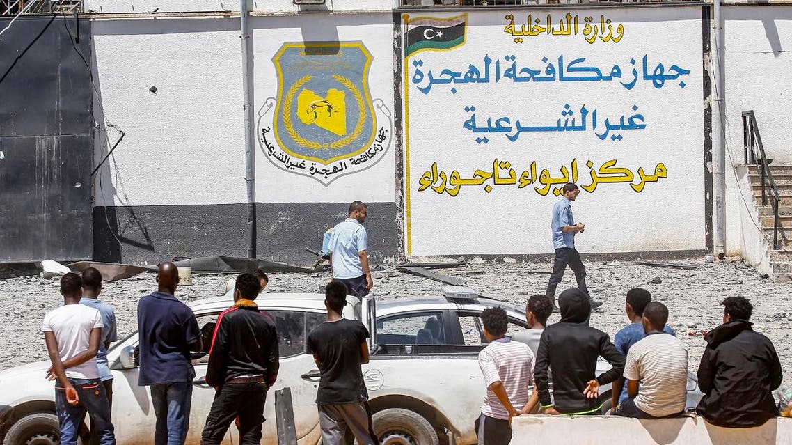 Migrants are seen outside at a detention centre used by the Libyan Government of National Accord (GNA) in the capital Tripoli's suburb of Tajoura. (AFP)