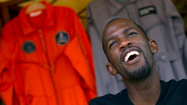 Mandla Maseko speaks to a journalist in front of two hanged NASA spacesuits on January 9, 2014, in Mabopane, north of Pretoria. (AFP)