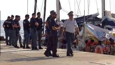 A still image from a video footage shows police officers guarding a migrant rescue boat, which docked at the port of Lampedusa in defiance of a ban on entering Italian waters. (Reuters)