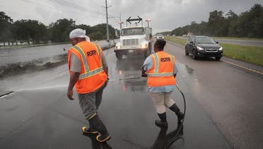 Workers clear debris left behind by Hurricane Barry on Highway 23 on July 14, 2019, near Myrtle Grove, Louisiana. (AFP)