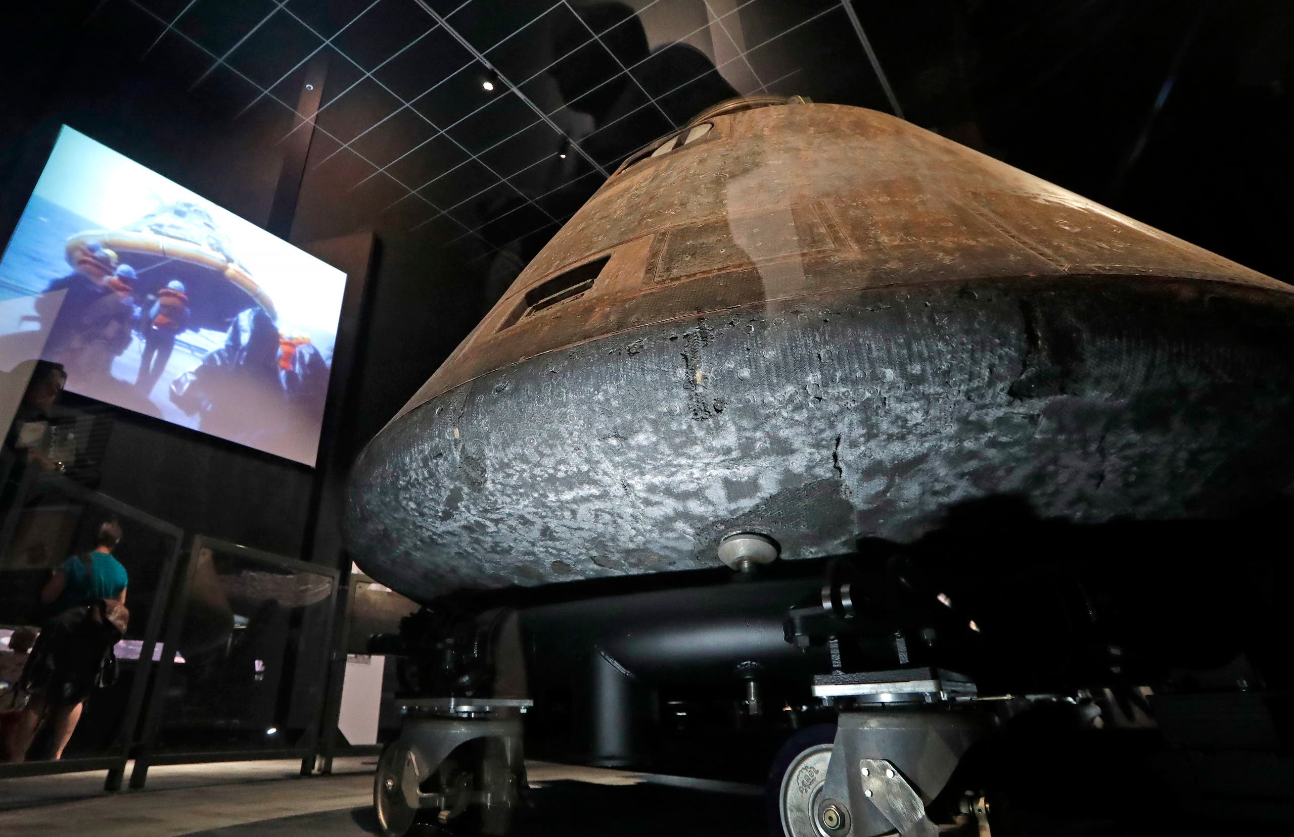 The NASA Apollo 11 command module Columbia, its bottom scorched and pitted from reentry into Earth's atmosphere decades earlier, is displayed at the centerpiece of an Apollo 11 mission exhibit at the Museum of Flight in Seattle. (AP)