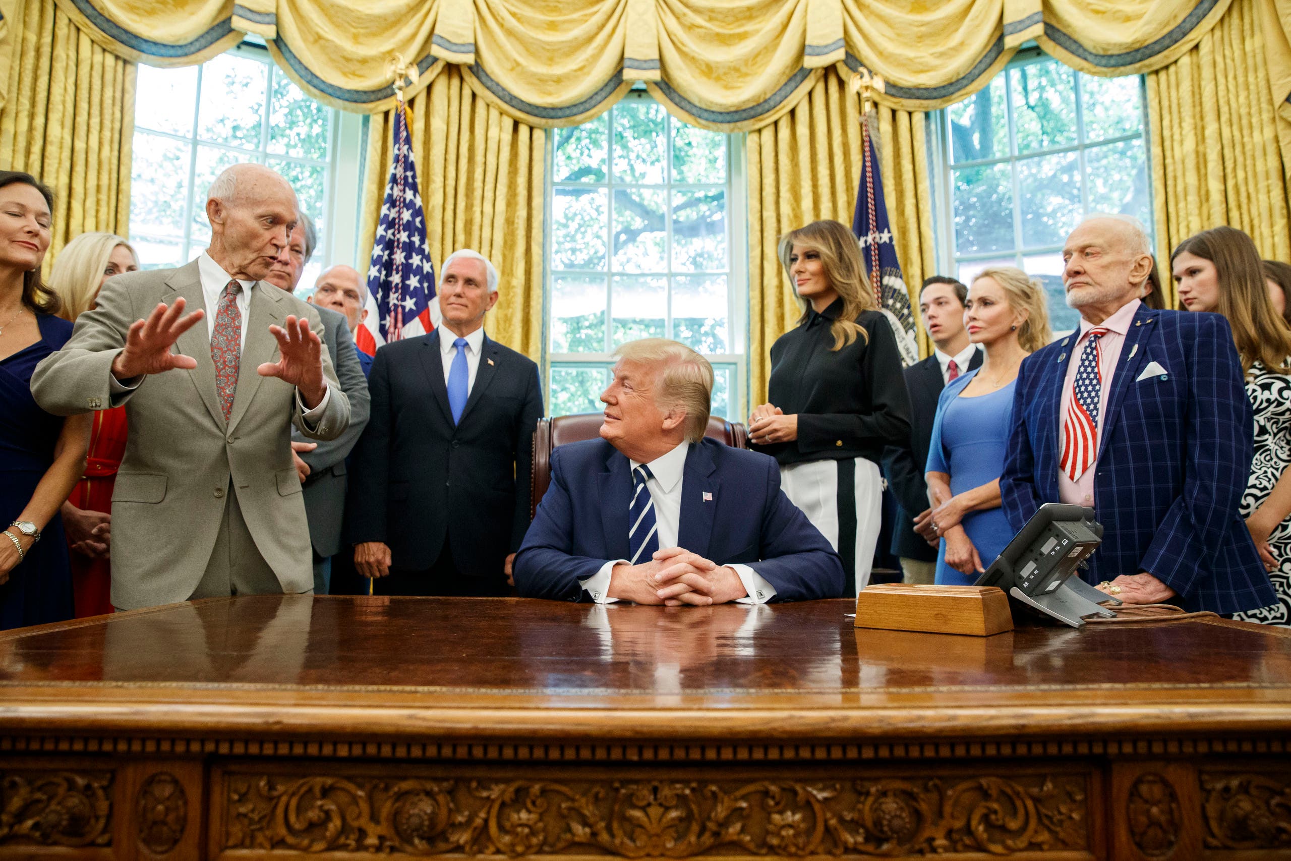 President Donald Trump, accompanied by Apollo 11 astronauts Michael Collins, left, and Buzz Aldrin, with Vice President Mike Pence and first lady Melania Trump, listens during a photo opportunity commemorating the 50th anniversary of the Apollo 11 moon landing, in the Oval Office of the White House. (AP)