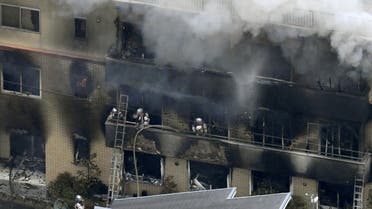 An aerial view shows firefighters battling the fires at the site where a man started a fire after spraying a liquid, at a three-story studio of Kyoto Animation Co. in Kyoto, western Japan (Reuters)