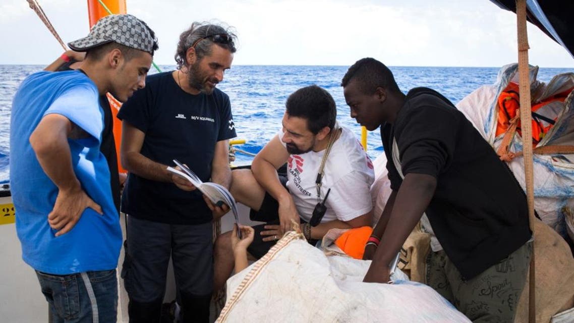A handout photo released on September 25, 2018 by SOS Mediterranee shows rescued migrants talking with crew members at the Aquarius rescue ship. (AFP)