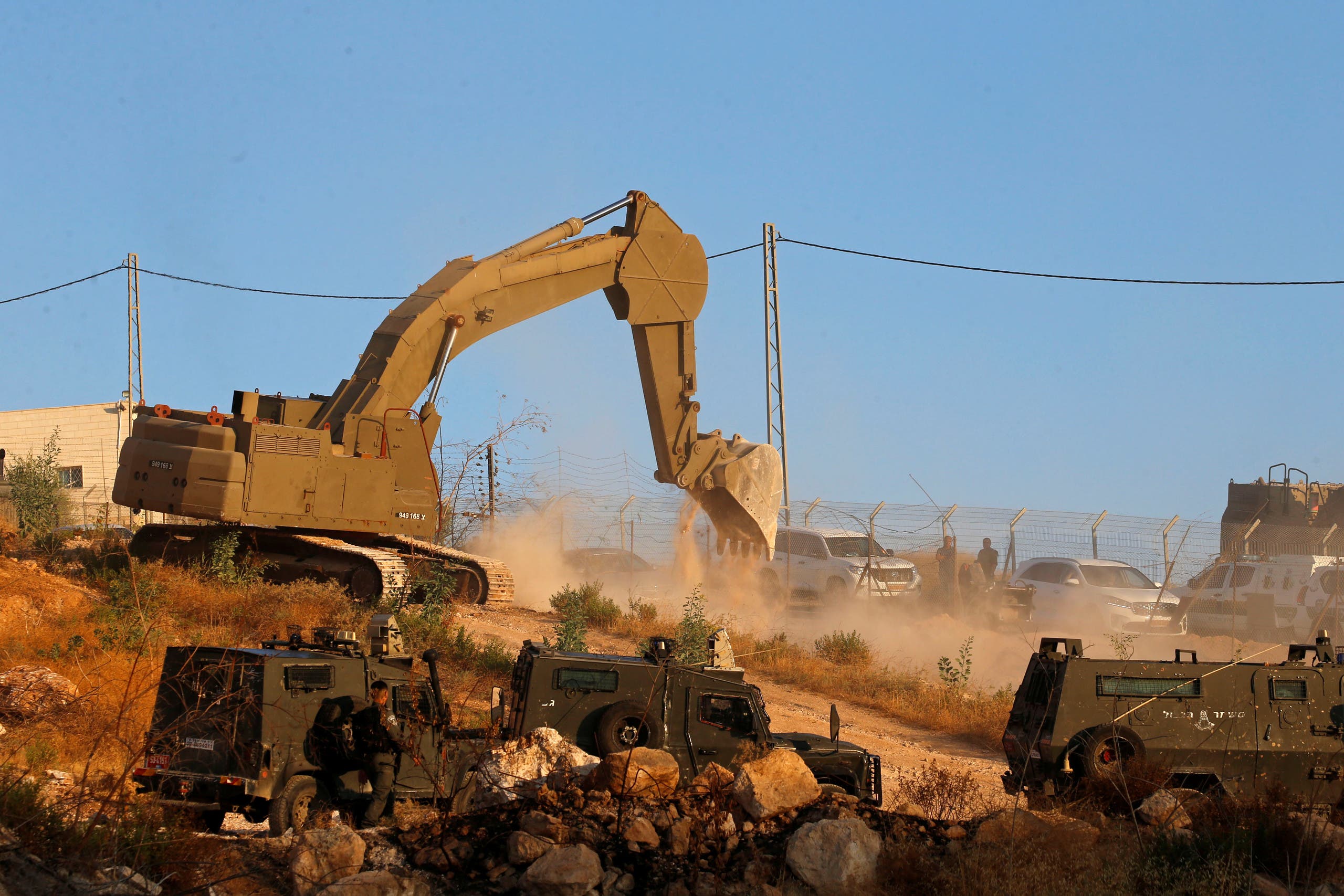 An Israeli machinery demolishes a Palestinian building in the village of Sur Baher which sits on either side of the Israeli barrier in East Jerusalem and the Israeli-occupied West Bank July 22, 2019. REUTERS