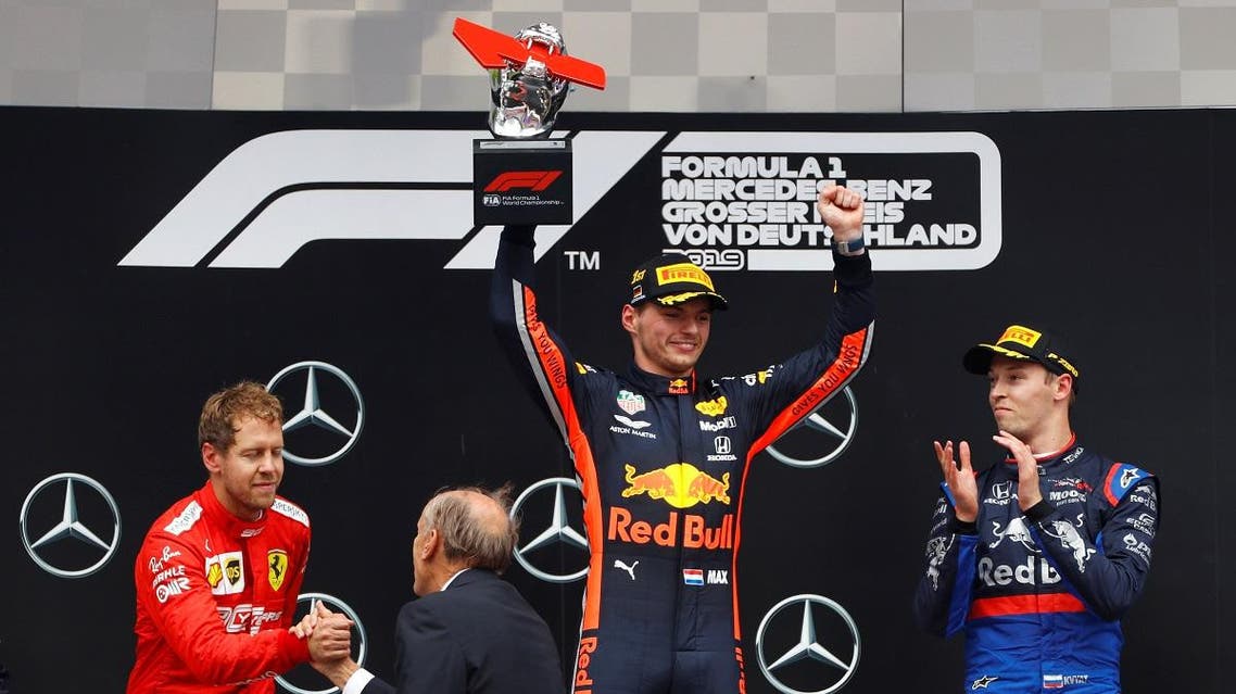 Red Bull's Max Verstappen lifts the winners trophy on the podium alongside second placed Sebastian Vettel of Ferrari and third placed Daniil Kvyat of Toro Rosso. (Reuters)