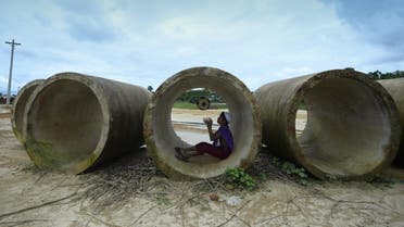 A Rohingya child plays with a football inside a sewage pipe at Kutupalong refugee camp in Ukhia on July 24, 2019. (AFP)