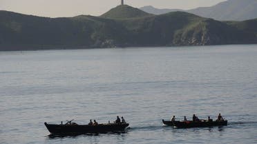 This picture taken on August 31, 2011 shows fishermen going out in their boats as the cruise ship Mangyongbong prepares to dock at Mount Kumgang port in the first-ever cruise from Rason in North Korea. (AFP)