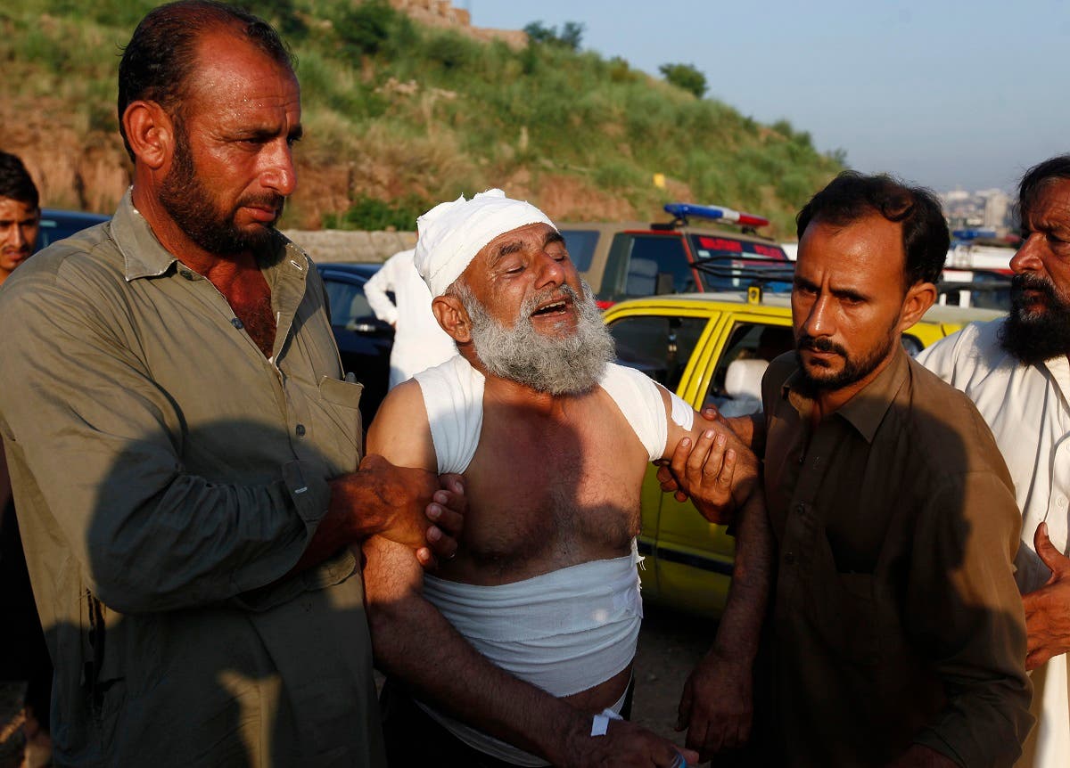 People help an injured man after a Pakistan army plane crash in Rawalpindi, Pakistan, Tuesday, July 30, 2019. (AP)