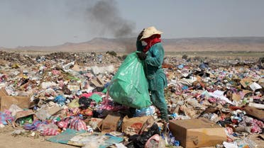 A Tunisian woman sifts through garbage on April 25, 2018 at a landfill in a poor district of Tunisia's central city of Kasserine. (File photo: AFP)